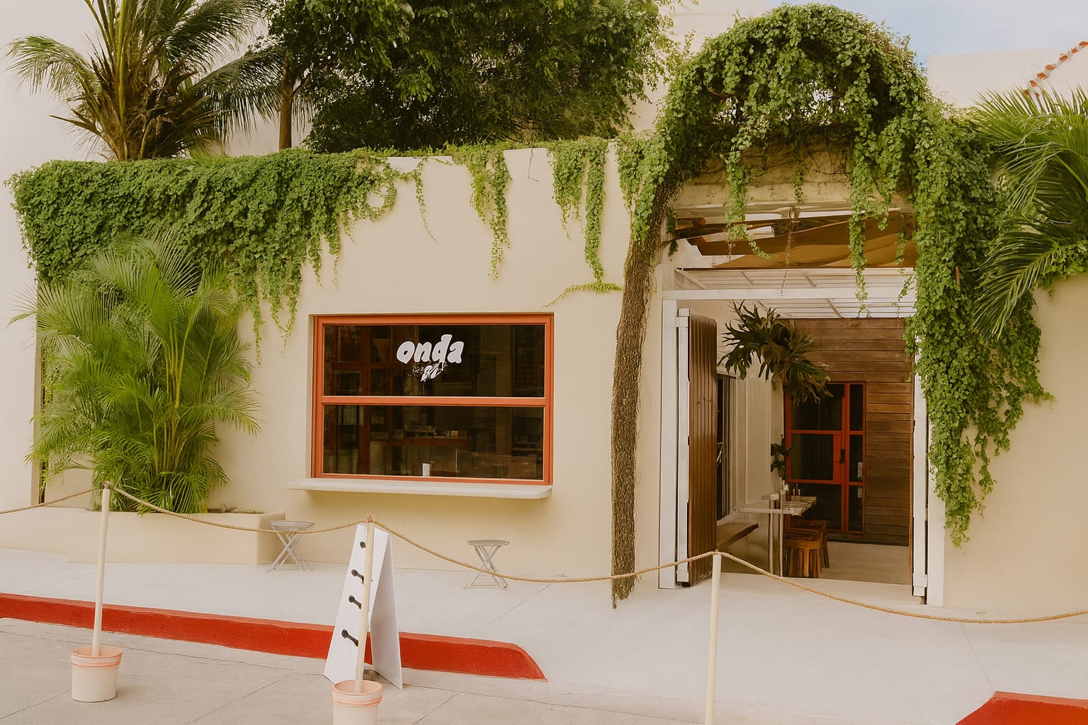 Fachada de Onda Café entre enredaderas